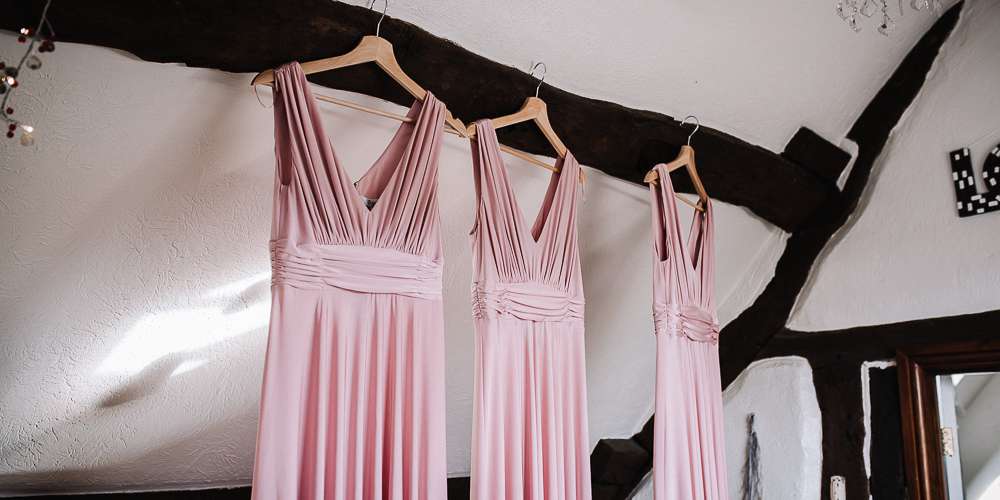 Bridesmaids dresses haning on the old beams.jpg