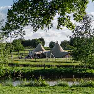 Rustic wedding tipi in a field with lake and stunning views