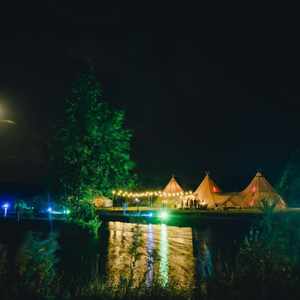 Tipis lit from lake - Alcott Weddings.jpg